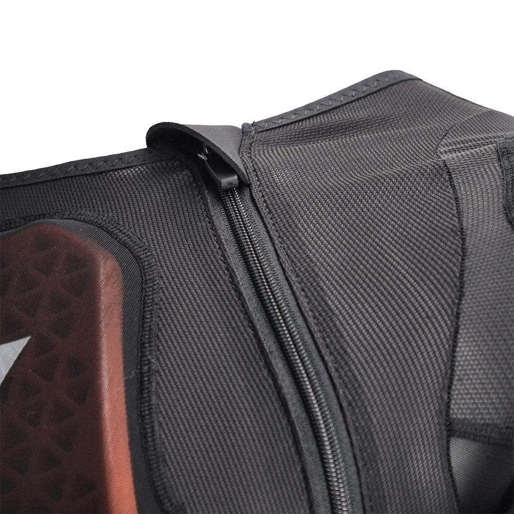 Black armored jacket close-up of side zipper and mesh textured fabric panels.