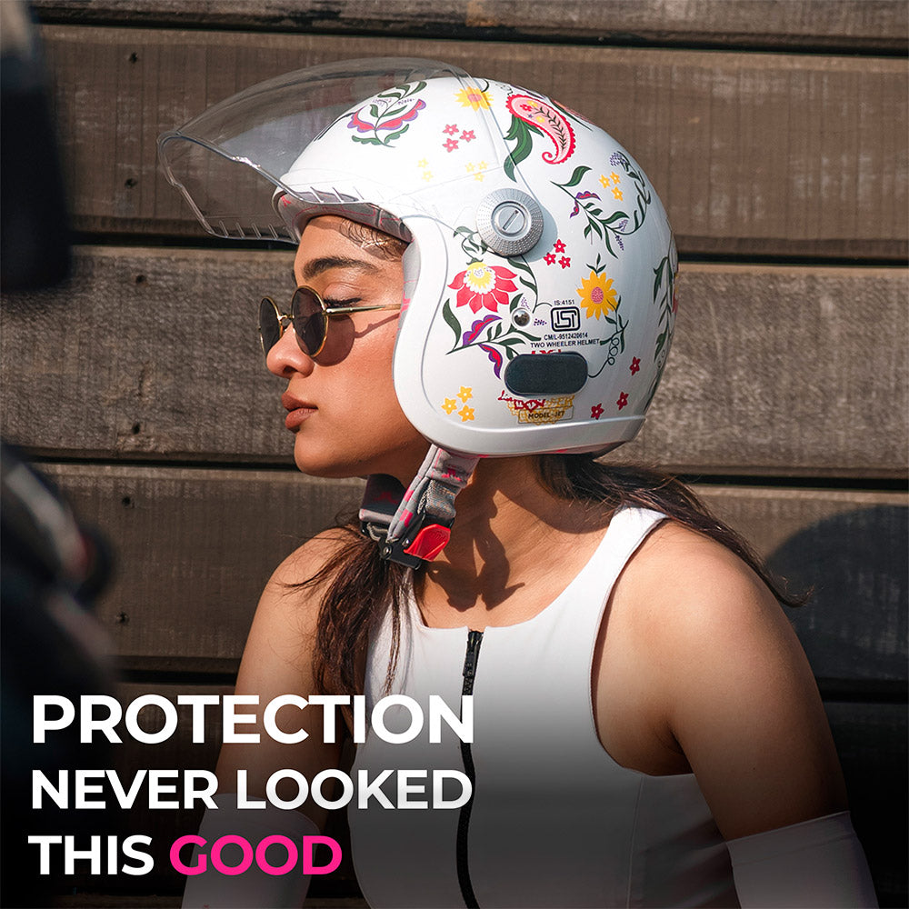 Women’s motorcycle helmet with clear visor, floral print, and chin strap, worn in profile