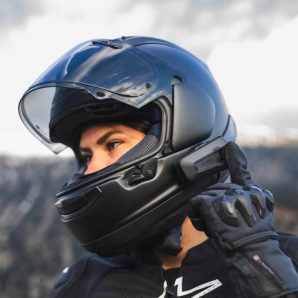 Black helmet intercom unit attached to motorcycle helmet with screen and buttons