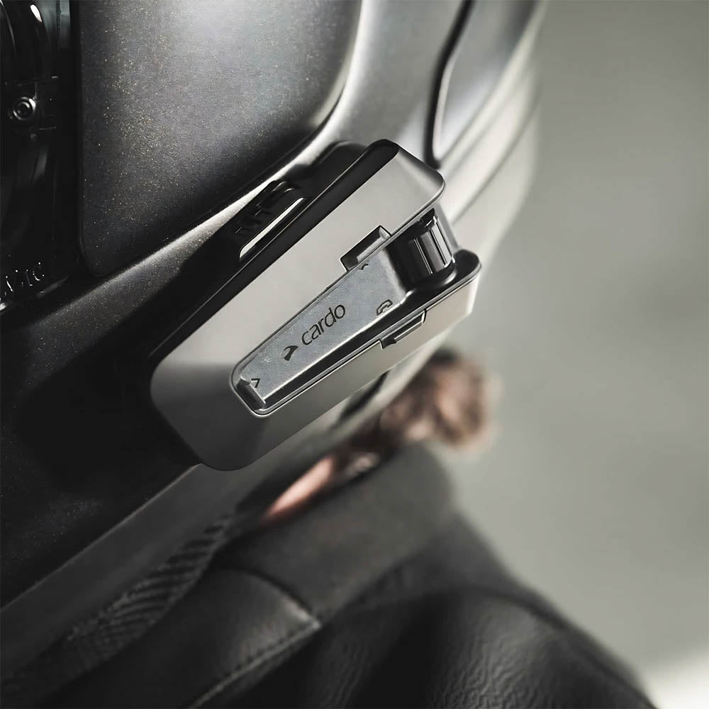 Black helmet-mounted intercom unit with display and green indicator light