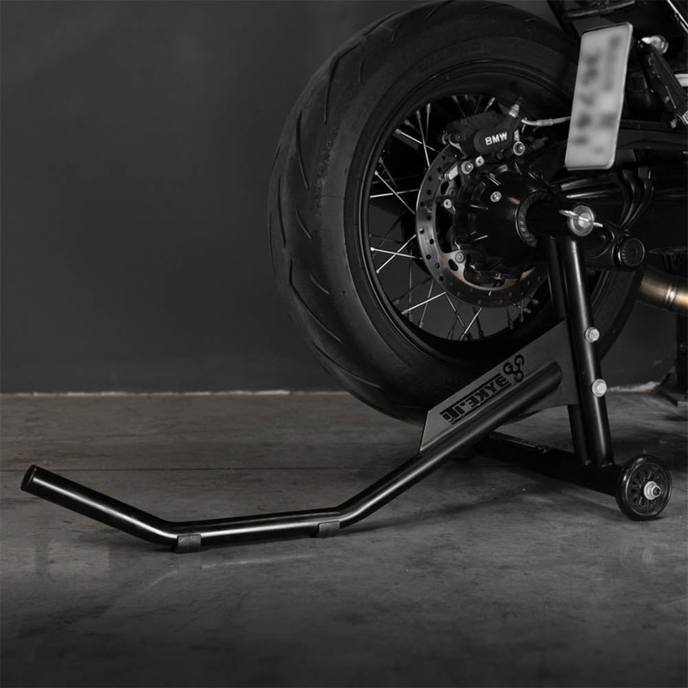 Black single-sided paddock stand lifting arm holding motorcycle rear wheel