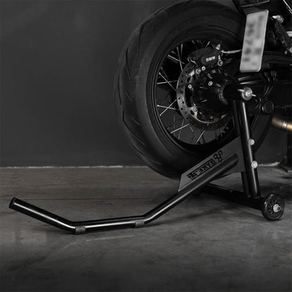 Black single-sided paddock stand lifting arm holding motorcycle rear wheel