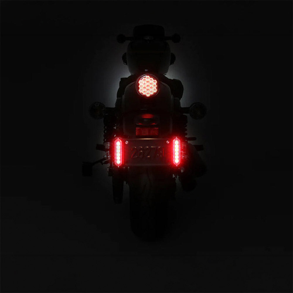 Red LED brake light glowing on a motorcycle tail section