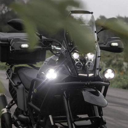 Black auxiliary LED light pods on a motorcycle front, spotlights glowing