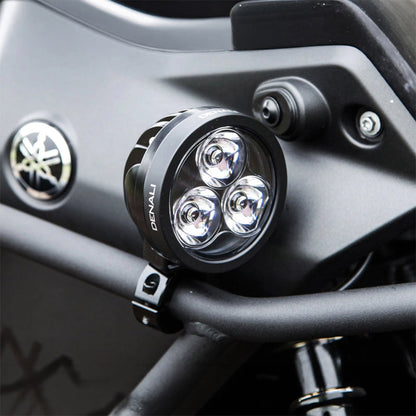 Black Denali D3 LED light pod with three-lens face, mounted on vehicle bracket