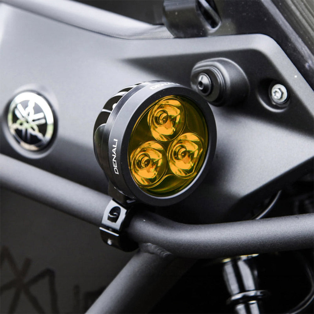 Black Denali D3 LED light pod casting amber glow from three lenses