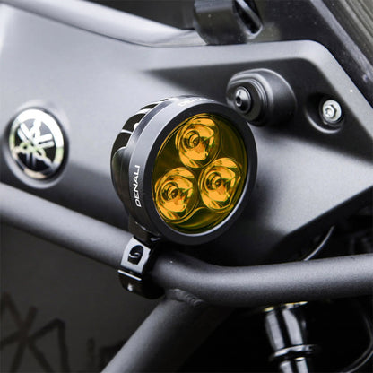 Black Denali D3 LED light pod casting amber glow from three lenses