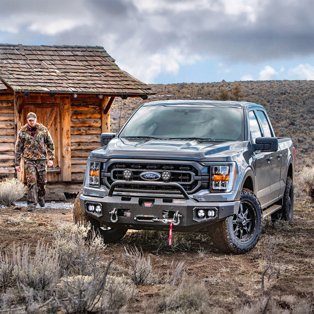 Black auxiliary LED light pods on an off-road truck front, headlights and pods lit