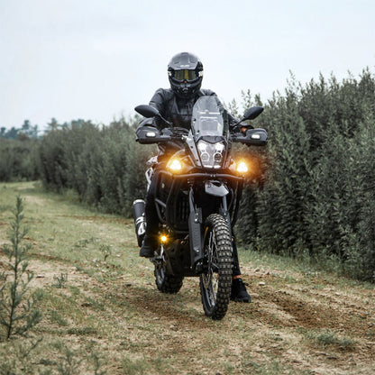 Black auxiliary LED light pods on a motorcycle front, headlamps on while riding