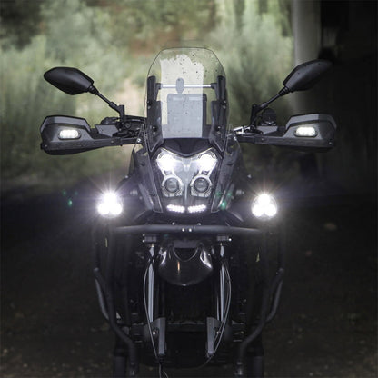 Black auxiliary LED light pods emitting bright beams on a motorcycle front view