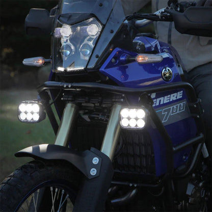 Illuminated driving light pods on motorcycle front, multi-LED lenses, black housings