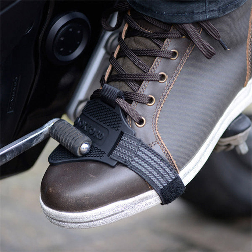 Black shoe protector toe guard strap with textured grip, secured on lace-up shoe