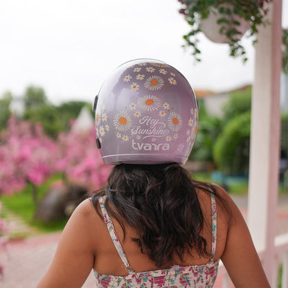 Lilac motorcycle helmet outdoors with daisy graphics and 'Hey Sunshine' design