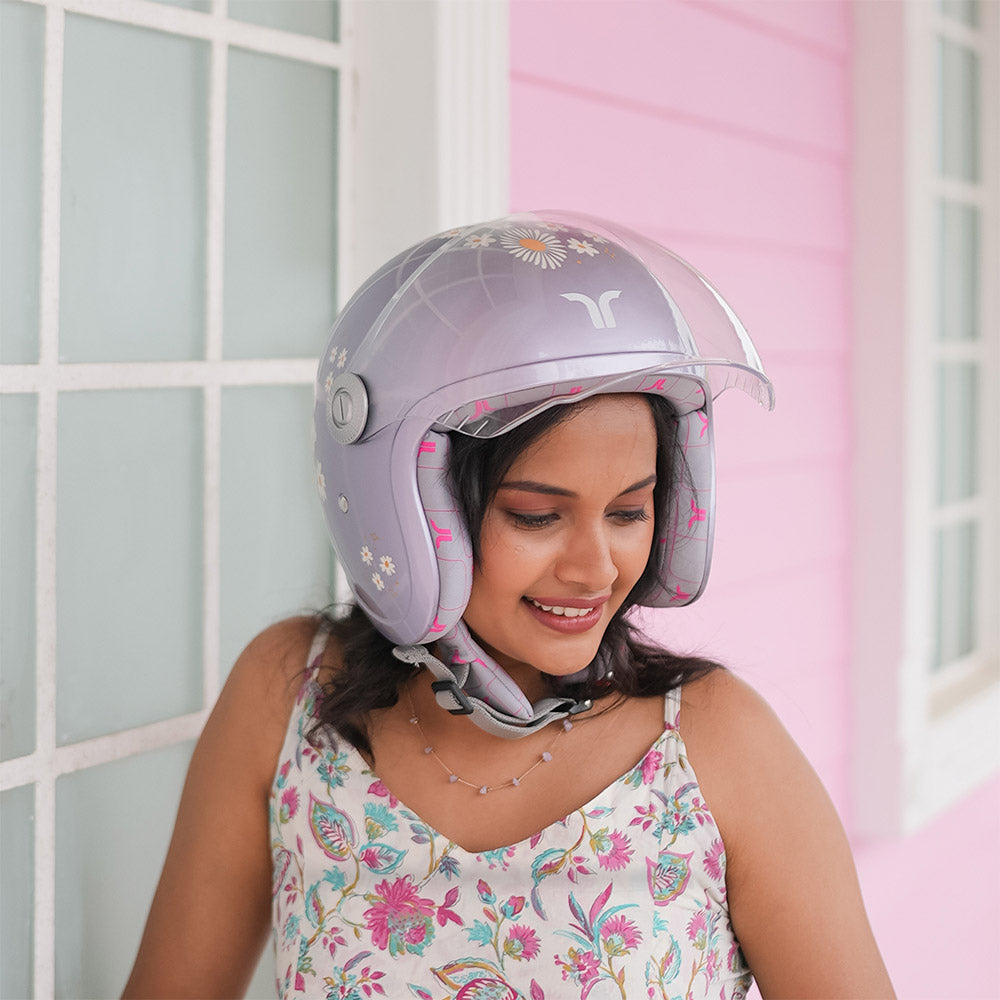 Woman wearing a lilac daisy motorcycle helmet with clear visor