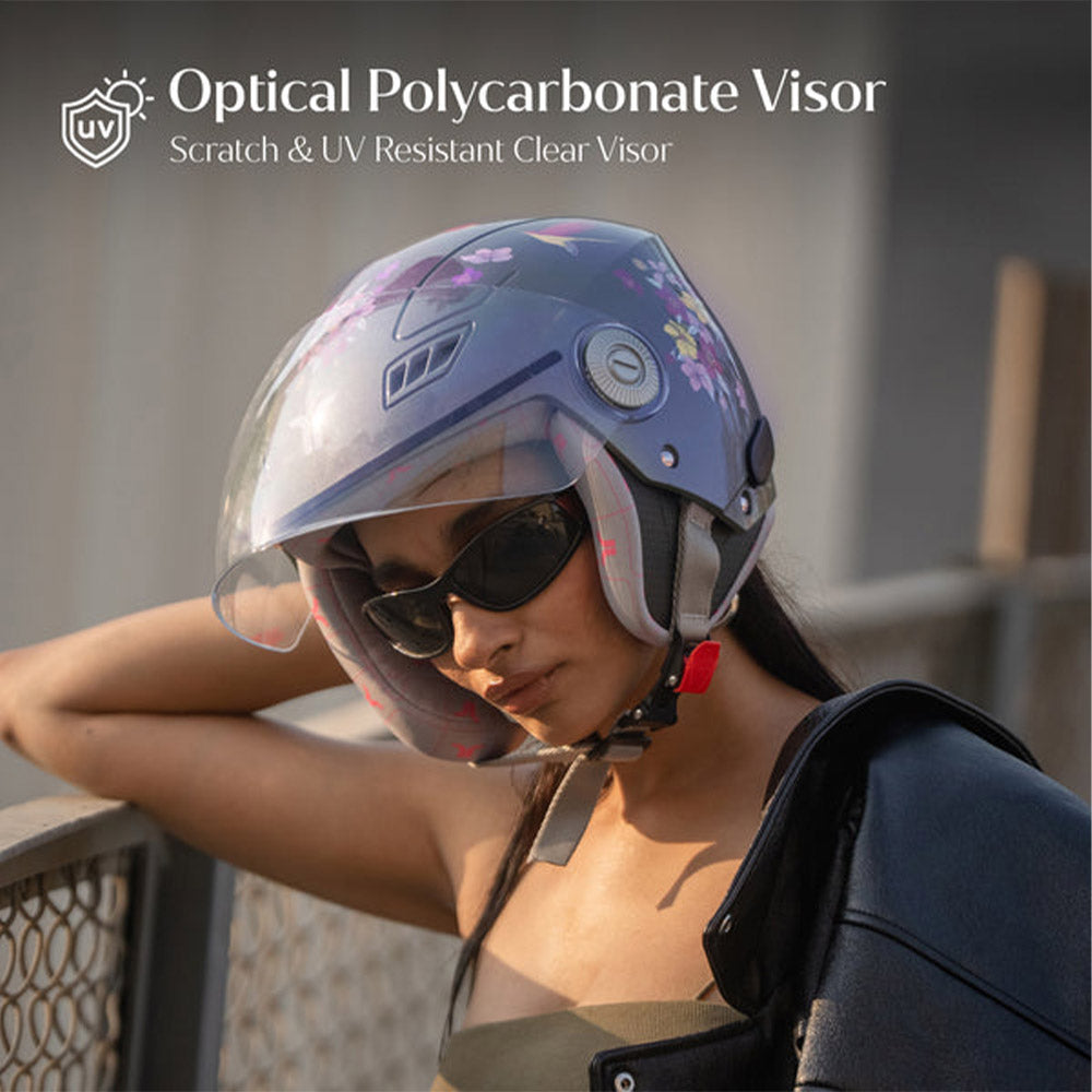 Motorcycle riding helmet with clear scratch-resistant visor, worn by a rider