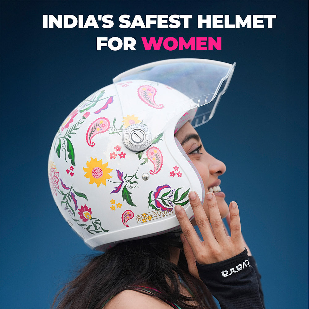 Women’s motorcycle helmet with colorful floral print and clear face visor, hand touching helmet
