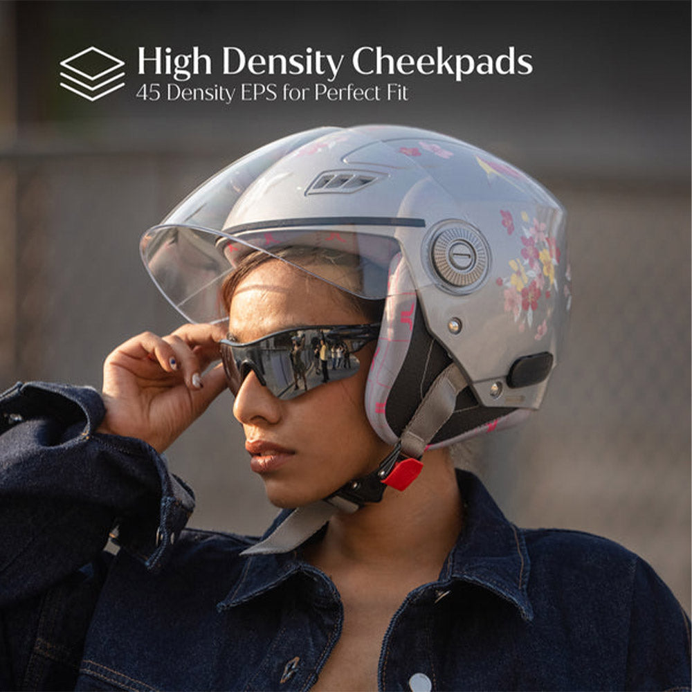 Woman wearing gray-silver motorcycle helmet with clear visor and floral graphics