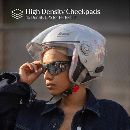 Woman wearing gray-silver motorcycle helmet with clear visor and floral graphics